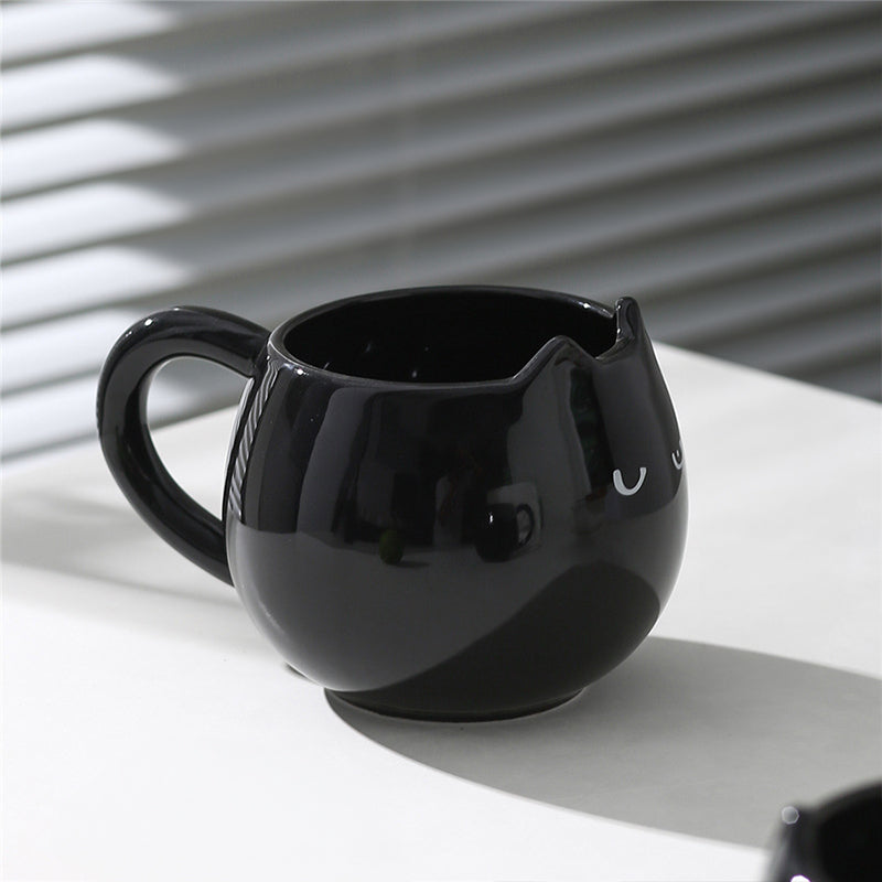Adorable hand - painted cat - shaped ceramic mug, perfect for coffee or tea.
