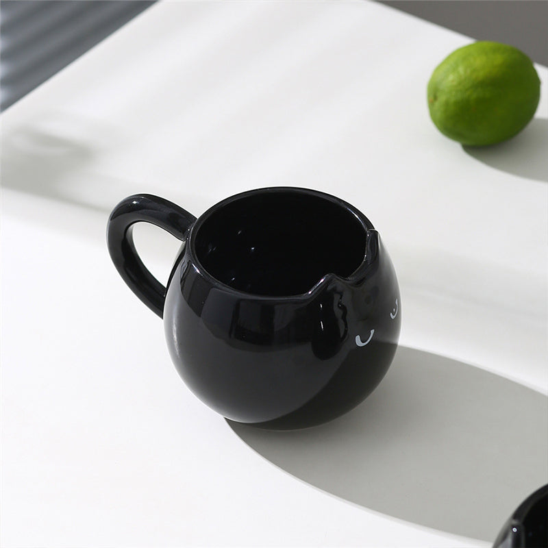Adorable hand - painted cat - shaped ceramic mug, perfect for coffee or tea.